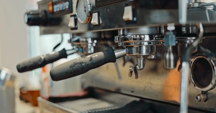 Close-up of a professional espresso machine portafilter handle.