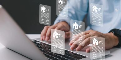 Person typing on laptop with floating digital house icons.