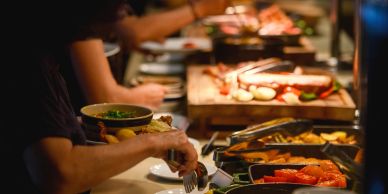 People serving themselves food at a buffet.