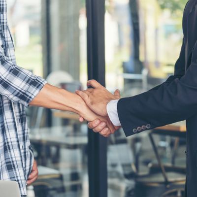 Two people shaking hands, signifying agreement or greeting.