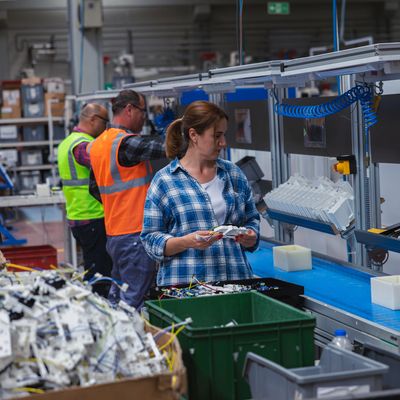Workers assembling in an automotive factory production line of an IATF 16949 certified company