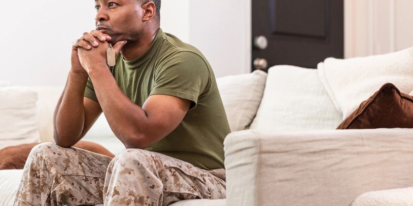 A man soldier sits on the sofa