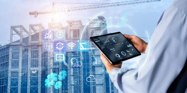 Engineer holding tablet in front of smart building data overlay symbolizing AI construction systems