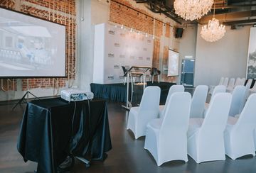 Conference room with white-covered chairs and projector setup.