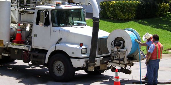 Technician fixing a drain under a sink.