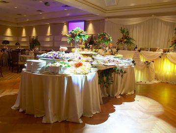 Elegant buffet table with floral decorations in a banquet hall.