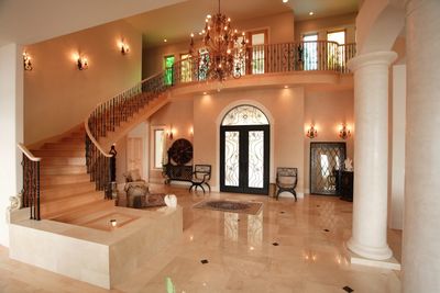 Luxurious foyer with marble floors and grand staircase.