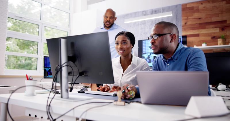 African Financial Data Analysts Using Performance Dashboard On Screens In Office