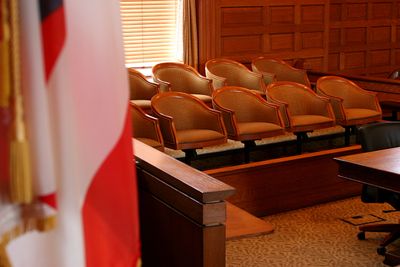 Empty courtroom with wooden decor and American flag.
