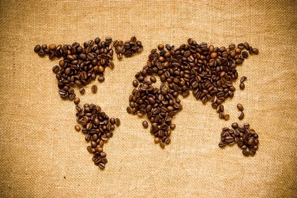 World map made of coffee beans on burlap fabric.