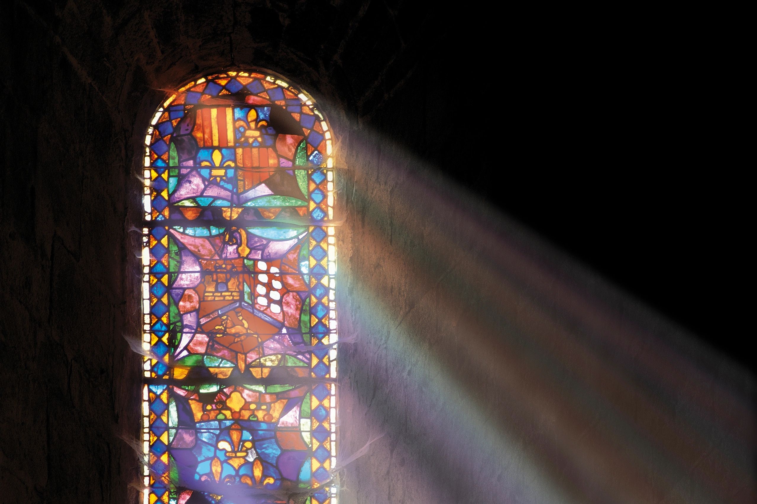 Stained glass window with sunlight streaming inside.