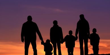 Silhouettes of diverse people holding hands.