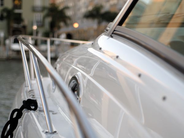 Close-up of a white boat's railing and side in soft light.