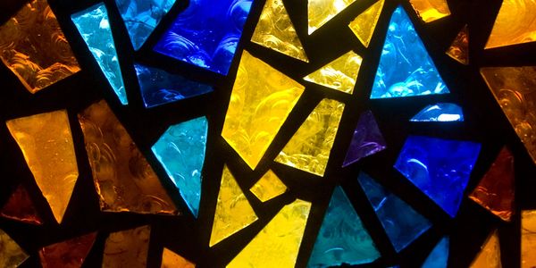 Colorful stained glass mosaic with blue, yellow, and orange hues.