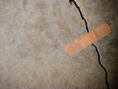 A band-aid placed over a crack on a concrete surface.