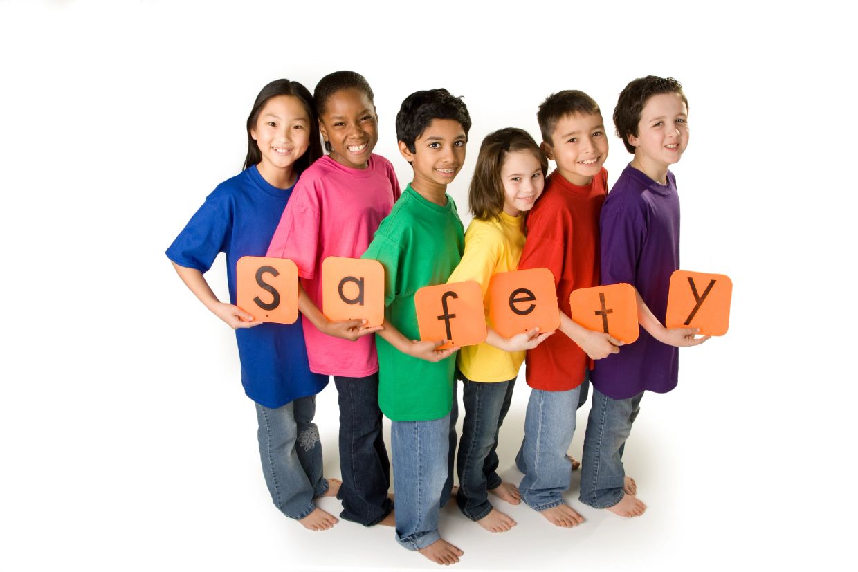 Children holding cards spelling the word 'safety' with colorful shirts.