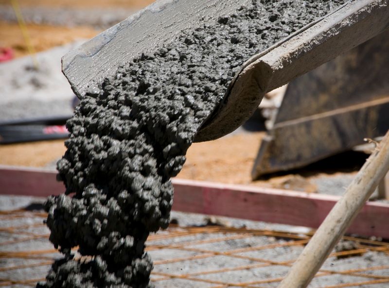 Concrete pouring from a truck for the construction of a new floor at a building site.  Note: Intentionally some motion blur on the moving concrete.