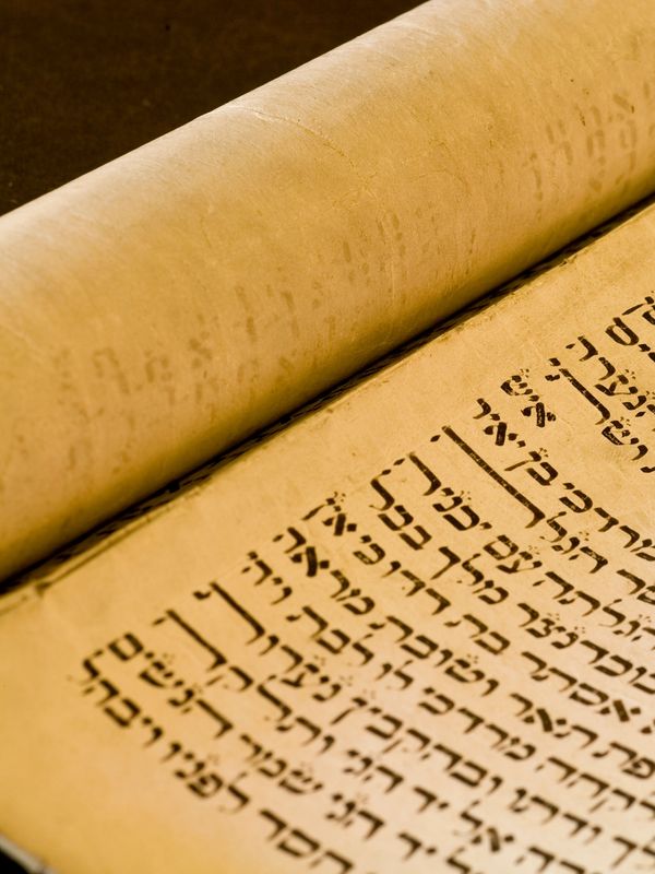 Close-up of an ancient Hebrew manuscript scroll with black ink text.