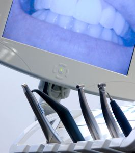 Dentist examining a patient's teeth in a modern dental office.