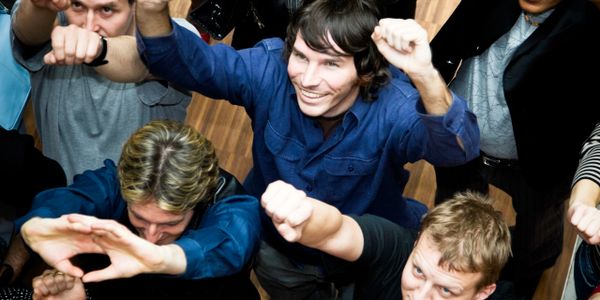 Group of people raising their fists enthusiastically towards the camera.