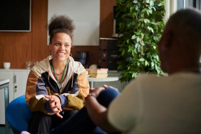 Two people having a friendly conversation indoors.