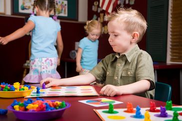 Children interact with a colorful food groups chart on a digital board.