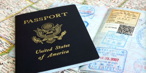 United States passport with visa stamps on a map background.