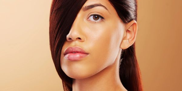 Close-up of a woman's face with hair partially covering one eye.