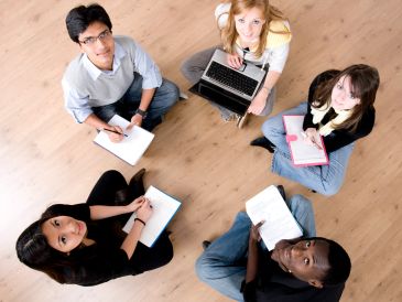 Group of diverse students studying together on the floor.