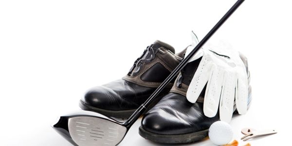 A golf ball near the hole on a green field.