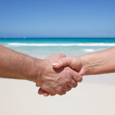 Handshake on a beach with ocean in the background.