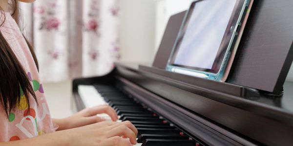 Student learning piano online through virtual music lessons