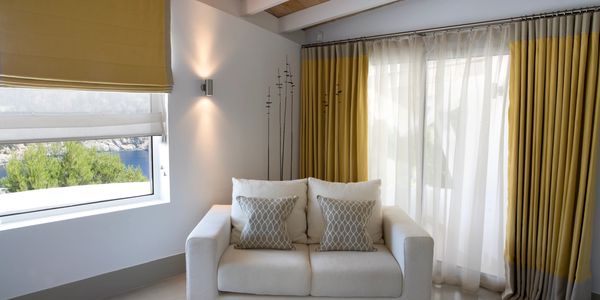 Minimalist living room with white sofa and yellow curtains.