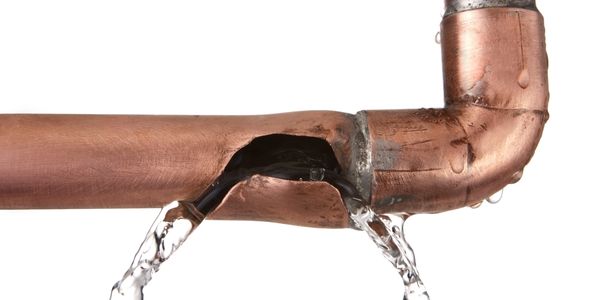Water leaking from a broken copper pipe joint.