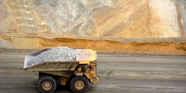 Large dump truck carrying gravel in an open mining site.
