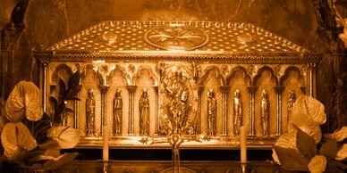 An ornate golden reliquary adorned with religious figures and decorations.