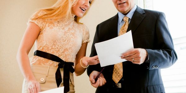 Two professionals reviewing documents together in an office setting.