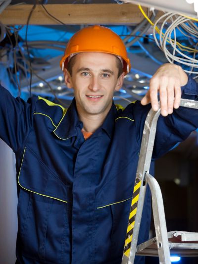 Male electrician in orange helmet and uniform.