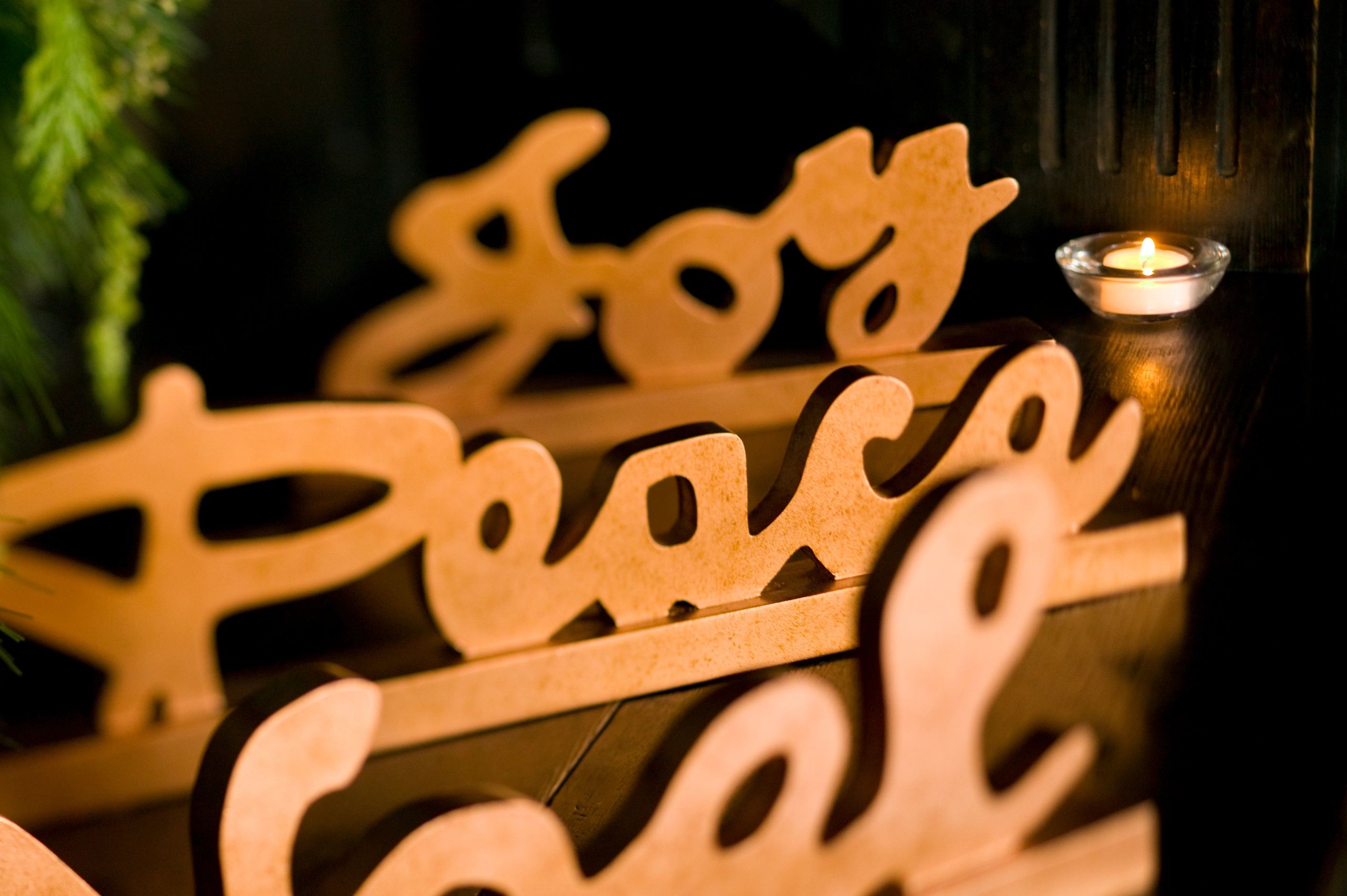 Wooden Christmas-themed decorations with a lit candle.