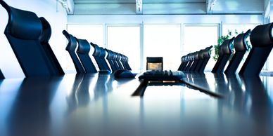 Modern conference room with black chairs and a long table.