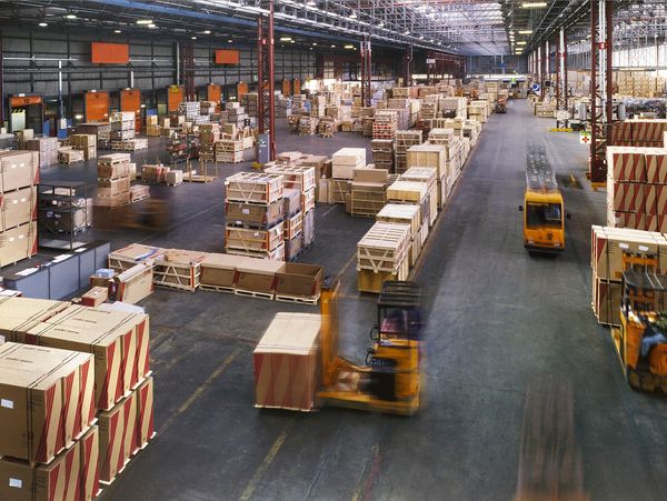 Kho hàng lớn với nhiều thùng carton và xe nâng.