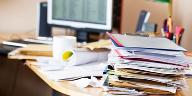Messy desk with papers and coffee cup.
