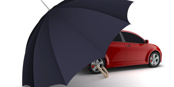Red car protected by large umbrella.