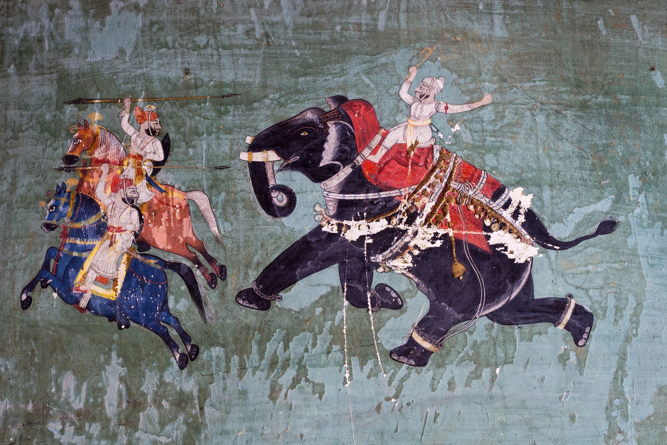 Ancient mural depicting warriors on horses and an elephant in battle.