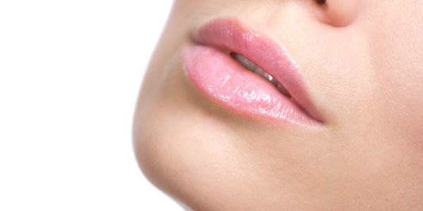 Close-up of glossy pink lips.