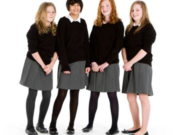 Four girls in school uniforms posing together.