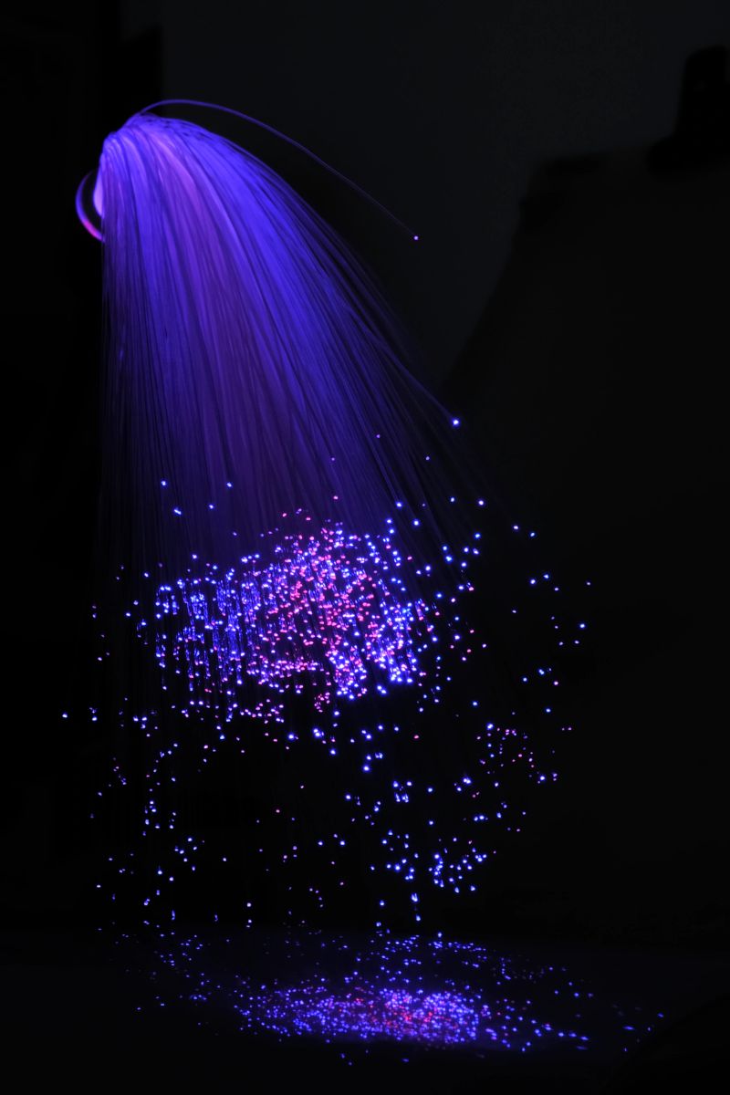 Blue optic fibers against a black background. Limited depth of field.