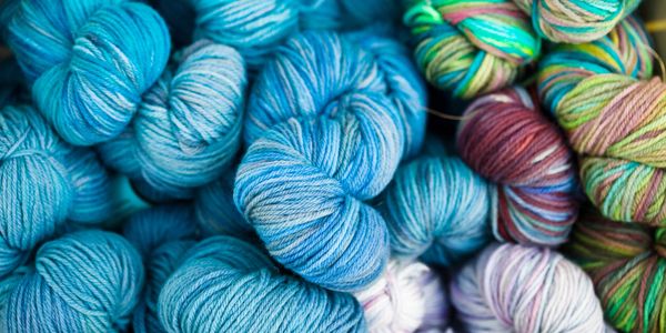 Colorful skeins of yarn in blue, green, pink, and purple shades.