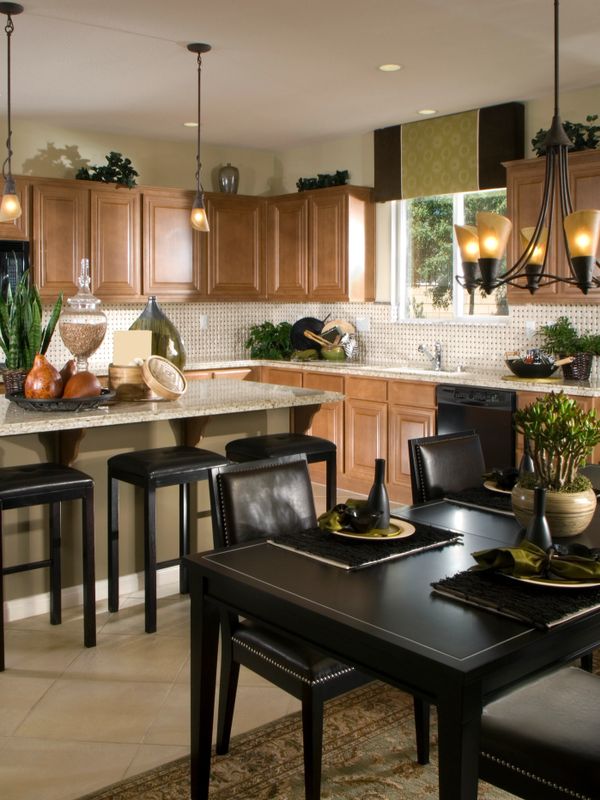 Modern kitchen and dining area with wooden cabinets and black furniture.