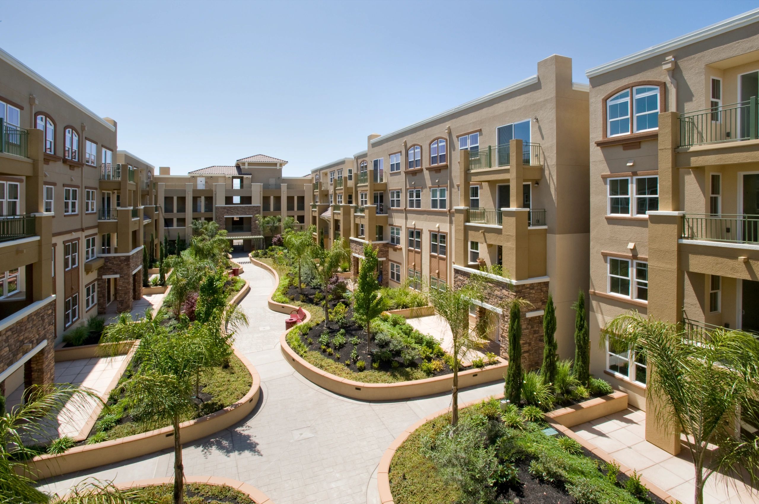 Courtyard view of a modern apartment complex with greenery.